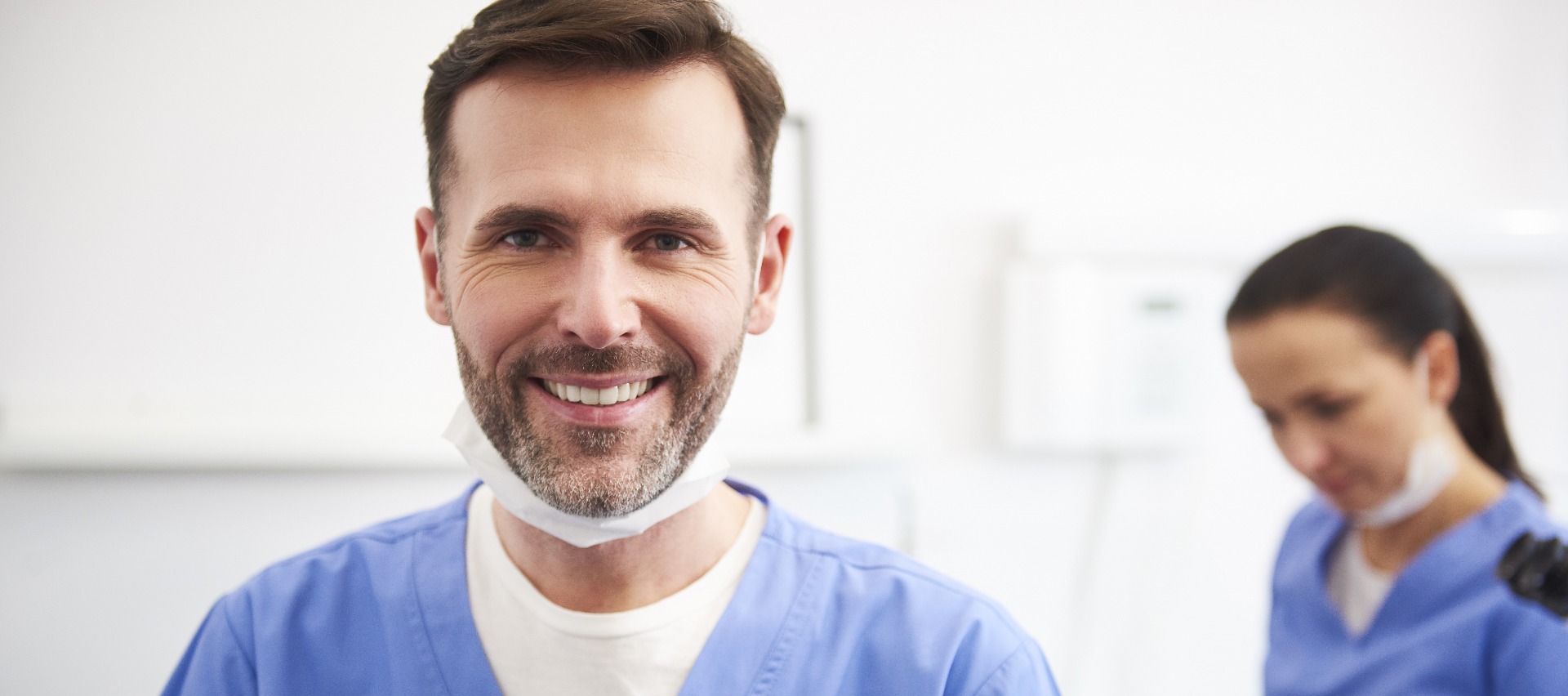 Dentiste souriant avec dentiste en arrière-plan